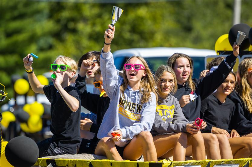 Students ride on a homecoming parade float